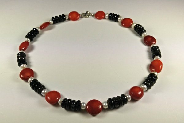 Eine Kette aus roten Baumkorallen-Linsen, Süßwasserperlen und Scheiben aus schwarzem Turmalin