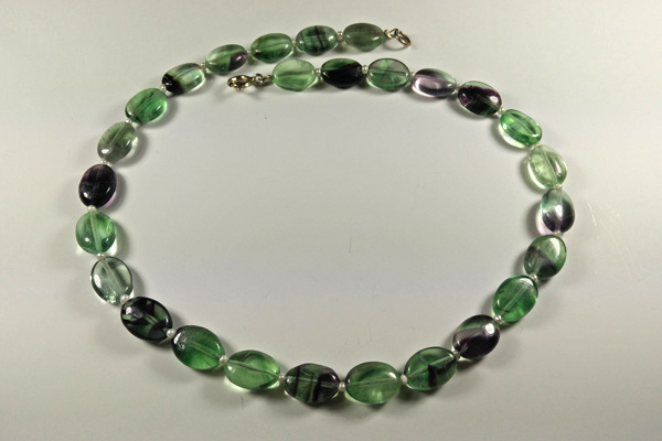 Fluorit-Kette aus ovalen durchsichtigen leuchtenden Perlen in grünen und lila Tönen, getrennt durch kleine weiße Süsswasserperlen