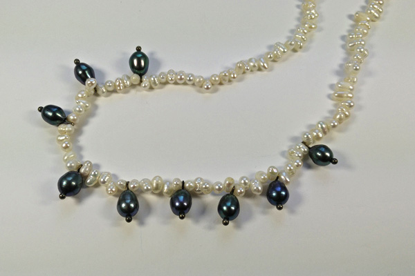Zierliche Kette aus kleinen weißen Süsswasserperlen und ovalen schwarzen Perlen, mit Silberkarabinerverschluss