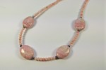 Eine zarte Kette aus 20 mm langen ovalen Rhodochrosit-Perlen, schwarzen Süßwasser Perlchen und runden rosa Baumkoralle-Perlen, mit Karabinerverschluss aus 925 Silber.